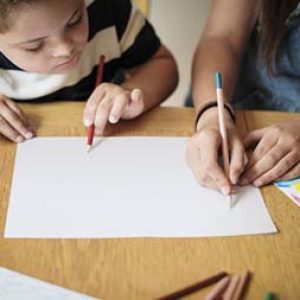 Sister and brother drawing at a table